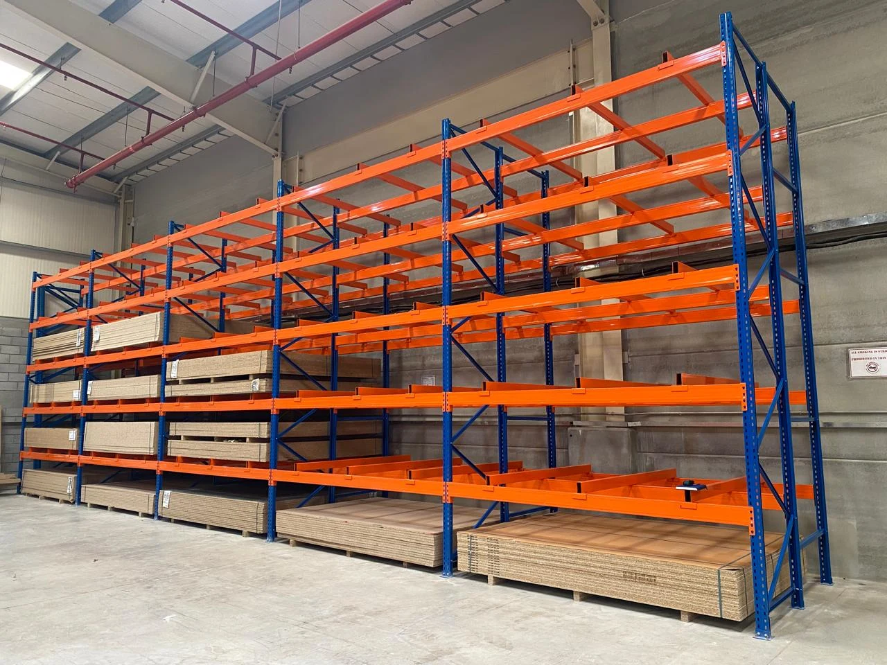 Pallet storage racks fully loaded with stacked boards in a UAE warehouse